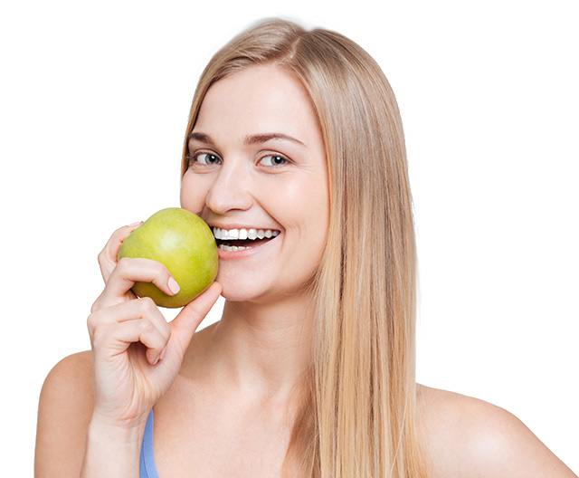 Smiling woman bites into an apple